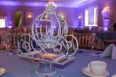 a fancy centerpiece sits on top of a blue table cloth at a wedding reception