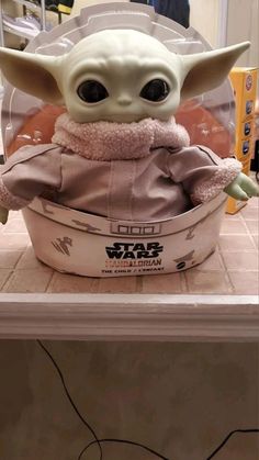 the baby yoda toy is sitting in a bowl