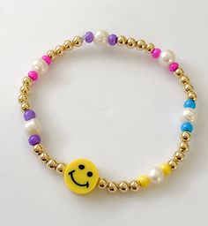 Smiley face bracelet / Happy face bracelet MATERIAL AND SIZE Colorful beads 18k Gold filled balls Fresh water pearls PC smiley face Elastic cord If you have questions about the product, feel free to reach me out. Don't forget to check out my other items in the store: Https://www.etsy.com/shop/nyahwithlove Cheap Yellow Beaded Bracelet With Smiley Face, Smiley Face Jewelry, Smiley Face Bracelet, Face Jewelry, 9 Month Old Baby, Face Jewellery, Face Necklace, Fresh Water Pearls, Themed Jewelry