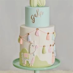 a three tiered cake decorated with llamas and tassels