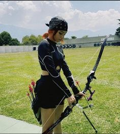 a woman in black outfit holding a bow and arrow