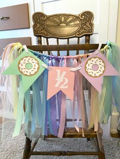 a baby crib decorated with colorful ribbons and paper decorations for a first birthday party