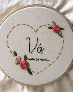 a white embroidered heart with pink roses and the word vos written in spanish on it