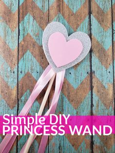 a pink and silver heart shaped paper wand on top of a wooden table with text overlay that reads, simple diy princess wand