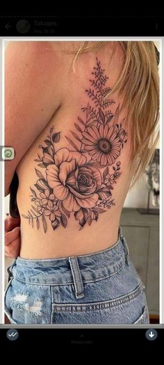 the back of a woman's stomach with flowers on it and leaves in the middle