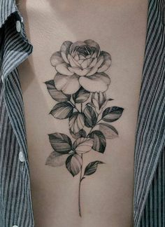 a black and white rose tattoo on the back of a woman's left arm