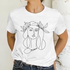 🖤FIND MORE TREASURES at MetisArtPrints * Explore our t-shirt collection! https://etsy.me/4bJMLv4 * Explore unique artworks! https://etsy.me/2Rw7KcO 🖤ABOUT This casual T-shirt features one of Picasso's famous drawings of women. It is the perfect gift for art lovers and artists alike. The unique design reflects Picasso's cubism style, adding an artistic touch to any wardrobe. 💯 HAPPINESS GUARANTEE * Your happiness is our priority. * If you have any issues with your order, let us know--we'll fix Picasso Woman, Lover Artwork, Francoise Gilot, Picasso Cubism, Gift For Artist, Semi Formal Wear, Woman Sketch, Woman Shirt, Gifts For Art Lovers