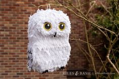 a paper owl hanging from a tree branch