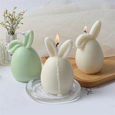 two candles with bunny ears on them sitting next to each other