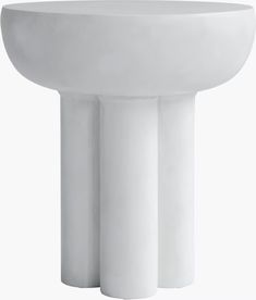 a white pedestal sink sitting on top of a table