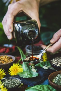 a person pouring some oil on top of flowers