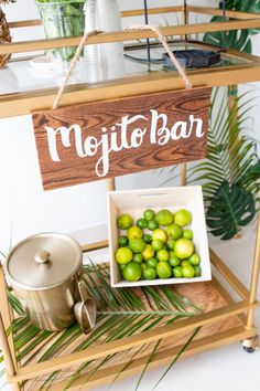 a wooden sign that says mojito bar next to a bowl of limes