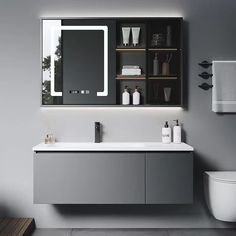 a bathroom with a toilet, sink and mirror