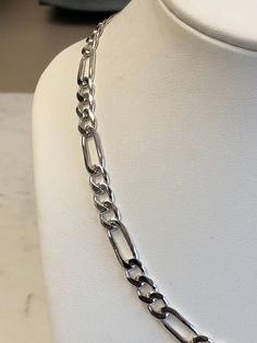 "Sterling Silver Unisex Solid Link Figaro Chain Necklace 18\" in Length. This chain is very flexible and comfortable to wear with its shiny bright plain polished finish. This chain has finished end caps and a lobster claw clasp closure and is 7mm wide and weighs 28.1 grams. This item would Retail for $429.00" Modern Silver Jewelry With Figaro Chain, Modern Silver Necklace With Figaro Chain, Silver Figaro Chain Necklace With Oval Links, Silver Figaro Chain Link Necklace, Silver Figaro Link Chain Necklace, Classic Silver Figaro Chain Necklace, Classic Sterling Silver Figaro Chain Necklace, Modern Sterling Silver Figaro Chain Necklace, Sterling Silver Figaro Chain Necklace With Oval Links