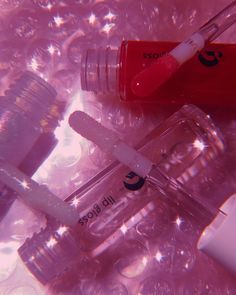 three different types of lip bales on top of clear plastic bottles with liquid in them