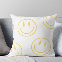 a smiley face pillow sitting on top of a couch