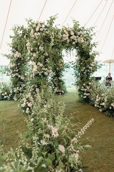 an outdoor ceremony with white flowers and greenery