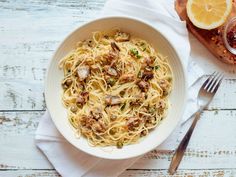 a white bowl filled with pasta and meat