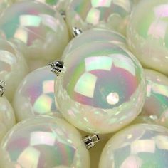 many white ornaments are arranged together on the table in front of some other balls and beads