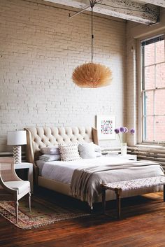 a bedroom with white brick walls and furniture