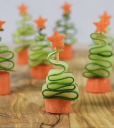 there are many small christmas trees made out of cucumber and carrot sticks on the table