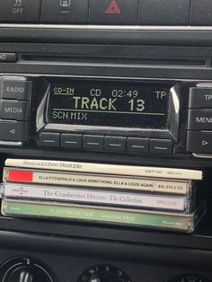 an old radio with cd's and cassettes on the dash board in front of it