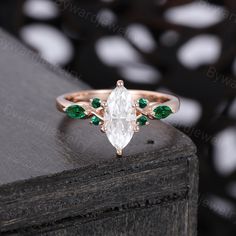 an engagement ring with green and white stones