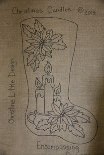 an embroidered christmas stocking with candles and poinsettis on the side, in black ink