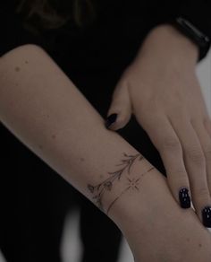 a woman's arm with a flower tattoo on the left side of her hand