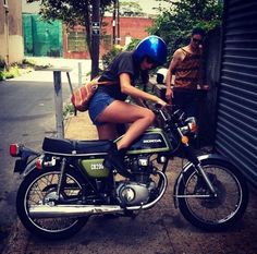 a woman sitting on the back of a motorcycle