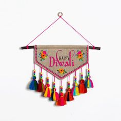 a wall hanging with colorful tassels and the words live simply written on it