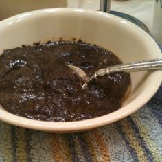 a white bowl filled with chocolate pudding on top of a blue and yellow table cloth