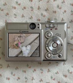 a digital camera sitting on top of a bed