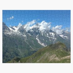 a jigsaw puzzle with mountains and clouds in the background on a sunny day