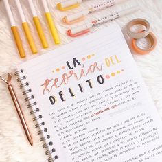 an open notebook with the words la ferra del alto written on it next to pens and scissors