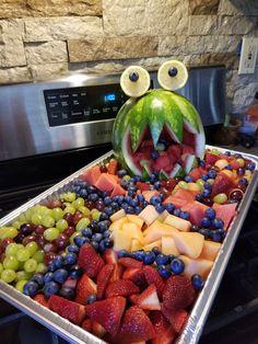 a watermelon face made out of fruit on top of a stove