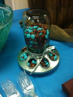 there is a cupcake maker with blue and brown candies in it on the table