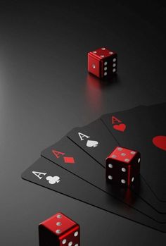 four red dices sitting on top of each other in front of some black cards