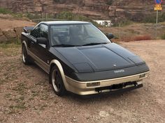 a car parked on the side of a dirt road