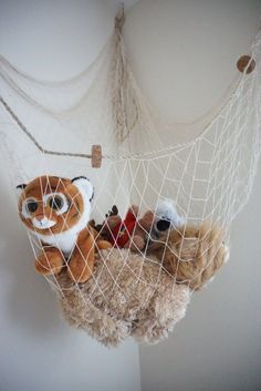 stuffed animals are in a hammock hanging from the ceiling and on top of each other