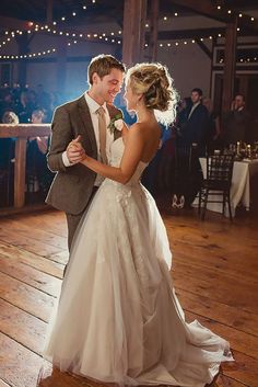 a bride and groom dance together at their wedding reception in an old - fashioned barn