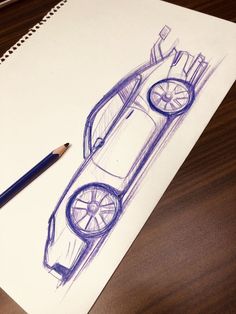 a pencil drawing of a sports car on top of a paper next to a pen