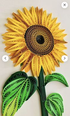 a paper sunflower made with green and yellow strips