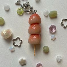 three candy lollipops sitting on top of each other with charms around them