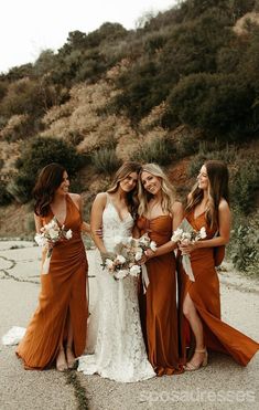 four bridesmaids pose for a photo in front of a mountain side with their bouquets