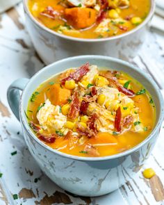 two bowls filled with soup on top of a wooden table