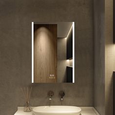 a bathroom sink sitting under a mirror next to a wall mounted toothbrush dispenser