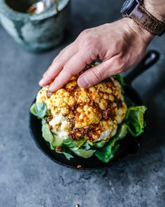 a hand reaching for some food on a plate