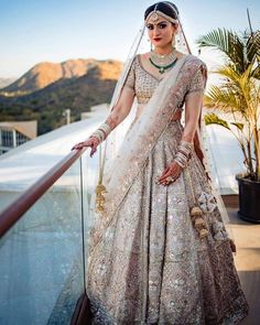 a woman in a bridal gown standing on a balcony