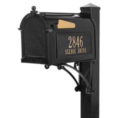 a black mailbox with gold lettering on the front and back of it's post